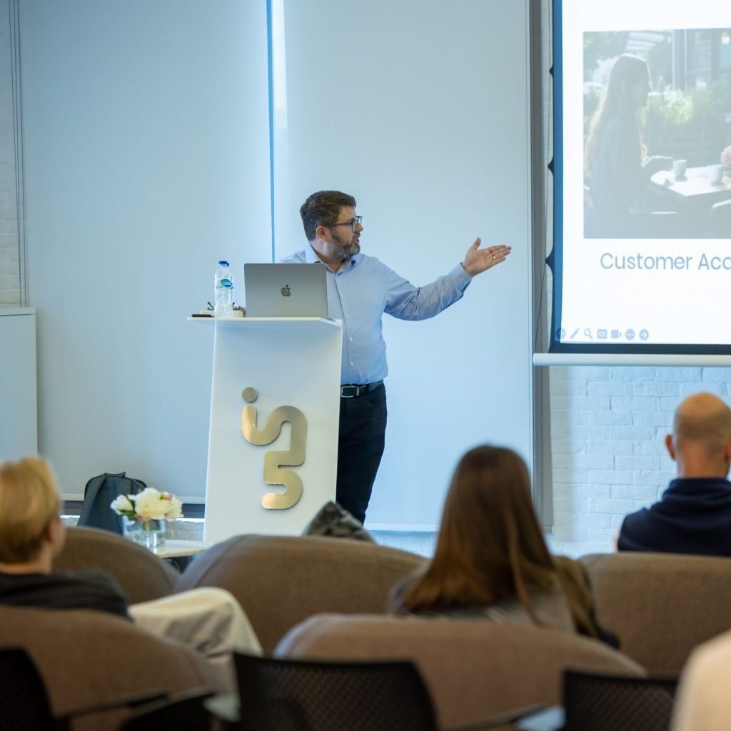 George giving a presentation at In5 campus for Dubai Media City. He is showing a screen and participants are looking.