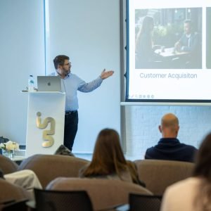 George giving a presentation at In5 campus for Dubai Media City. He is showing a screen and participants are looking.