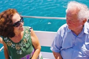 my dad and mom on a boat near pylos.. they are smiling with the brilliant blue water behind them